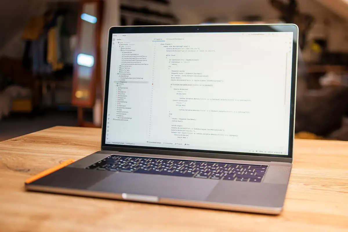 Laptop z otwartym plikiem konfiguracyjnym stojący na drewnianym biurku